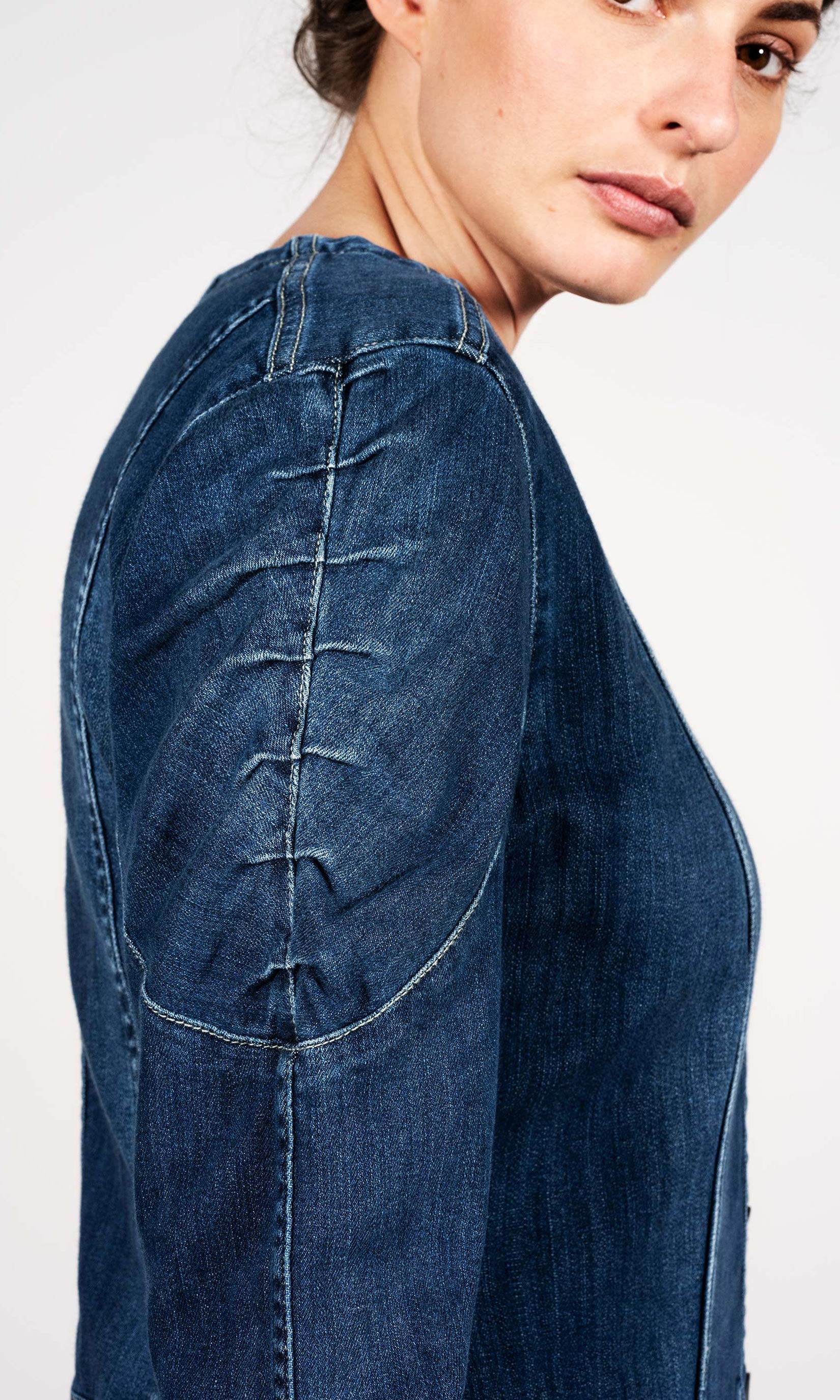 Long denim jacket with gathered details on the shoulders